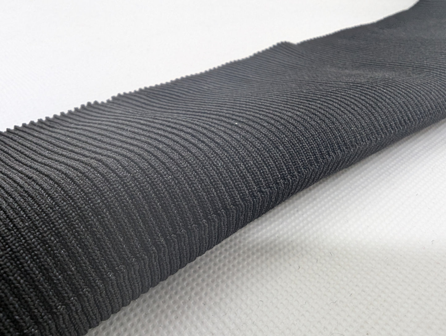 Bord-côte noir en polyester brillant et élasthanne